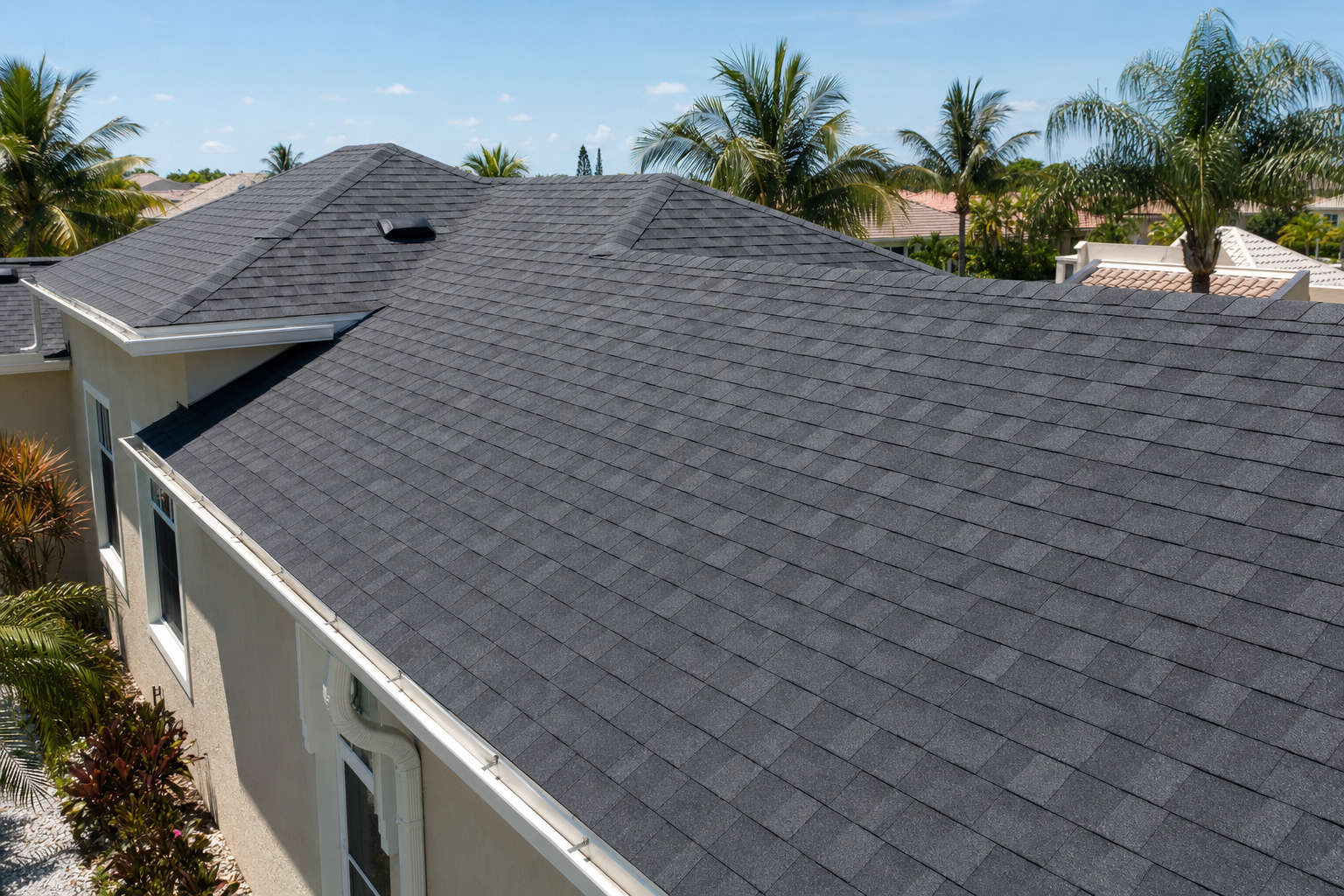 documentary photo of a South Florida asphalt shingle roof on a stucco home with palm trees nearby, clean afternoon light, realistic residential roofing detail, no people, no text