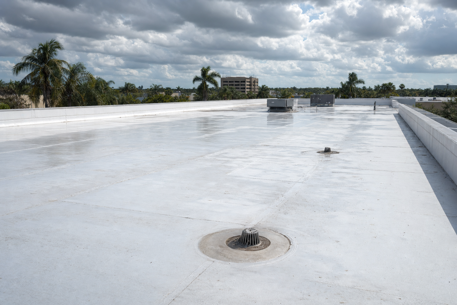 foto documental de un techo plano comercial en el sur de Florida con drenaje visible y áreas limpias de membrana clara, cielo nublado tropical, sin trabajadores, sin texto visible